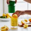 Sur La Table Manual Citrus Juicer – High-Performance Hand Juicer with Clear Measuring Cup, Yellow Reaming Cone, Green Plunger & Metal Prong for Maximum Juice Extraction